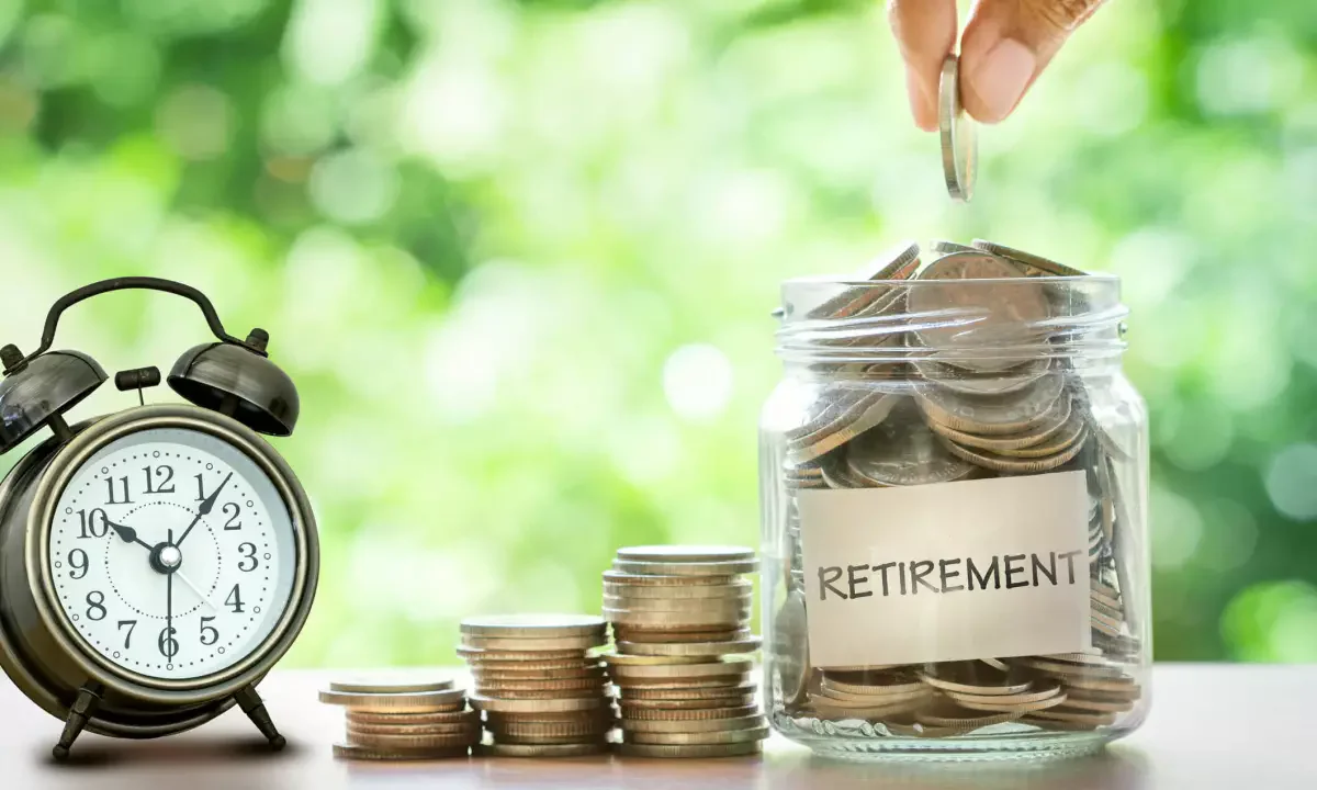 Bocal rempli de pièces étiqueté « retirement » à côté d’un réveil, symbolisant l’épargne retraite PER et la fiscalité dans le temps