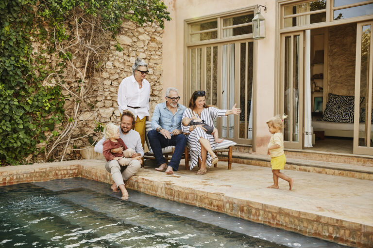 Famille de plusieurs générations réunie au bord d'une piscine avec des enfants