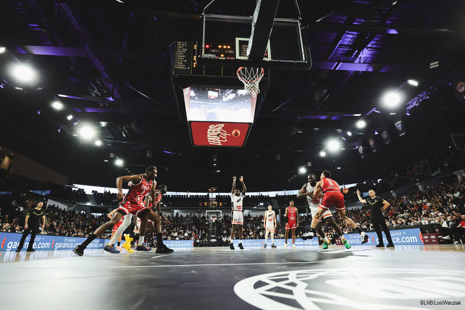 ©LNB/LoicWacziak Match de basket professionnel avec branding Garance sur le panneau LED, symbolisant le partenariat Garance–LNB