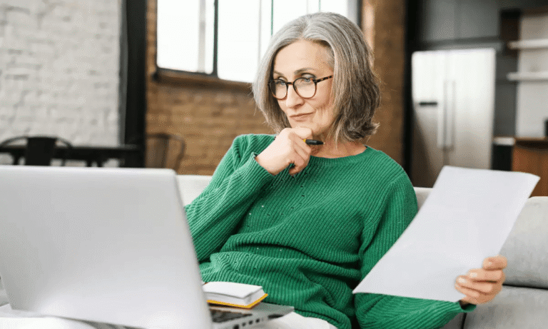 Femme réfléchissant devant un ordinateur, illustrant la réflexion sur sa retraite avec Garance Retraite