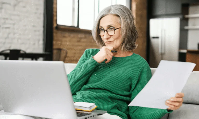 Femme réfléchissant devant un ordinateur, illustrant la réflexion sur sa retraite avec Garance Retraite