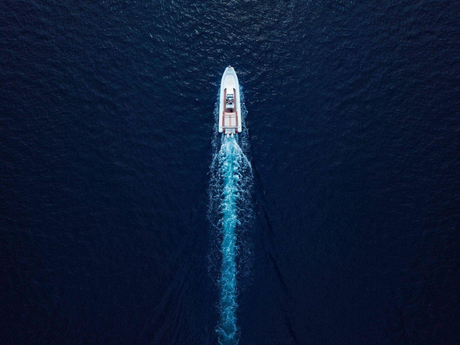Bateau à moteur avançant en pleine mer vu du ciel
