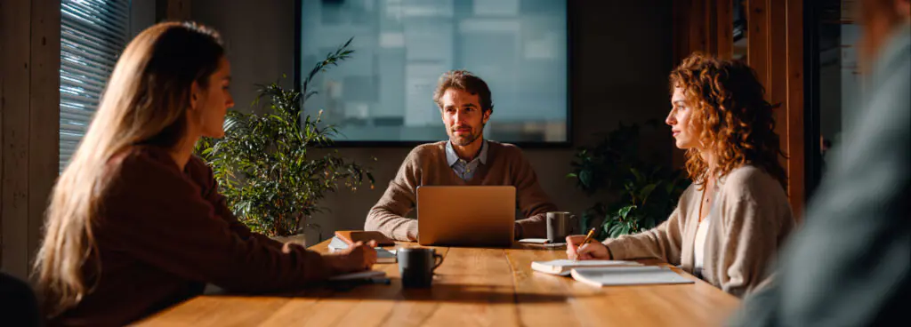 3 employés en réunion illustrant la collaboration
