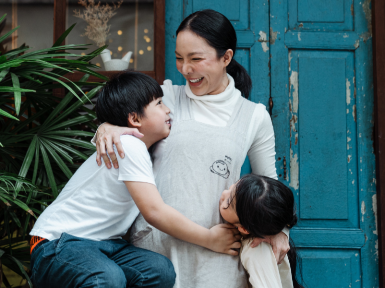 Une mère entourée de deux enfants, illustrant l’épargne de précaution et le besoin de protection financière du foyer.