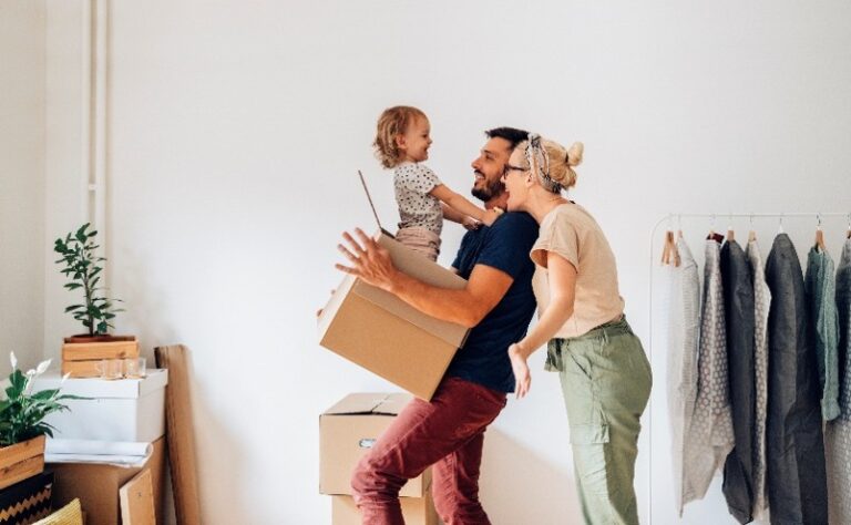 Famille avec un enfant emménageant dans un nouveau logement avec des cartons